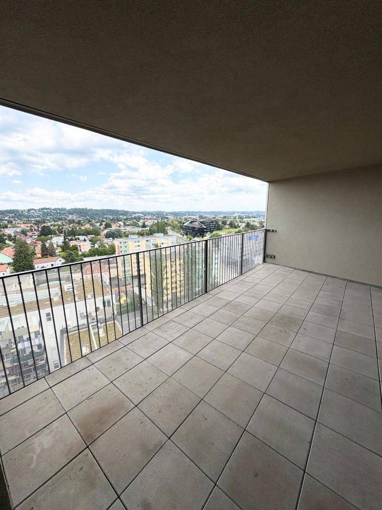 Geräumige Terrasse mit Fliesenboden und weitem Blick über die Stadt und die Umgebung.