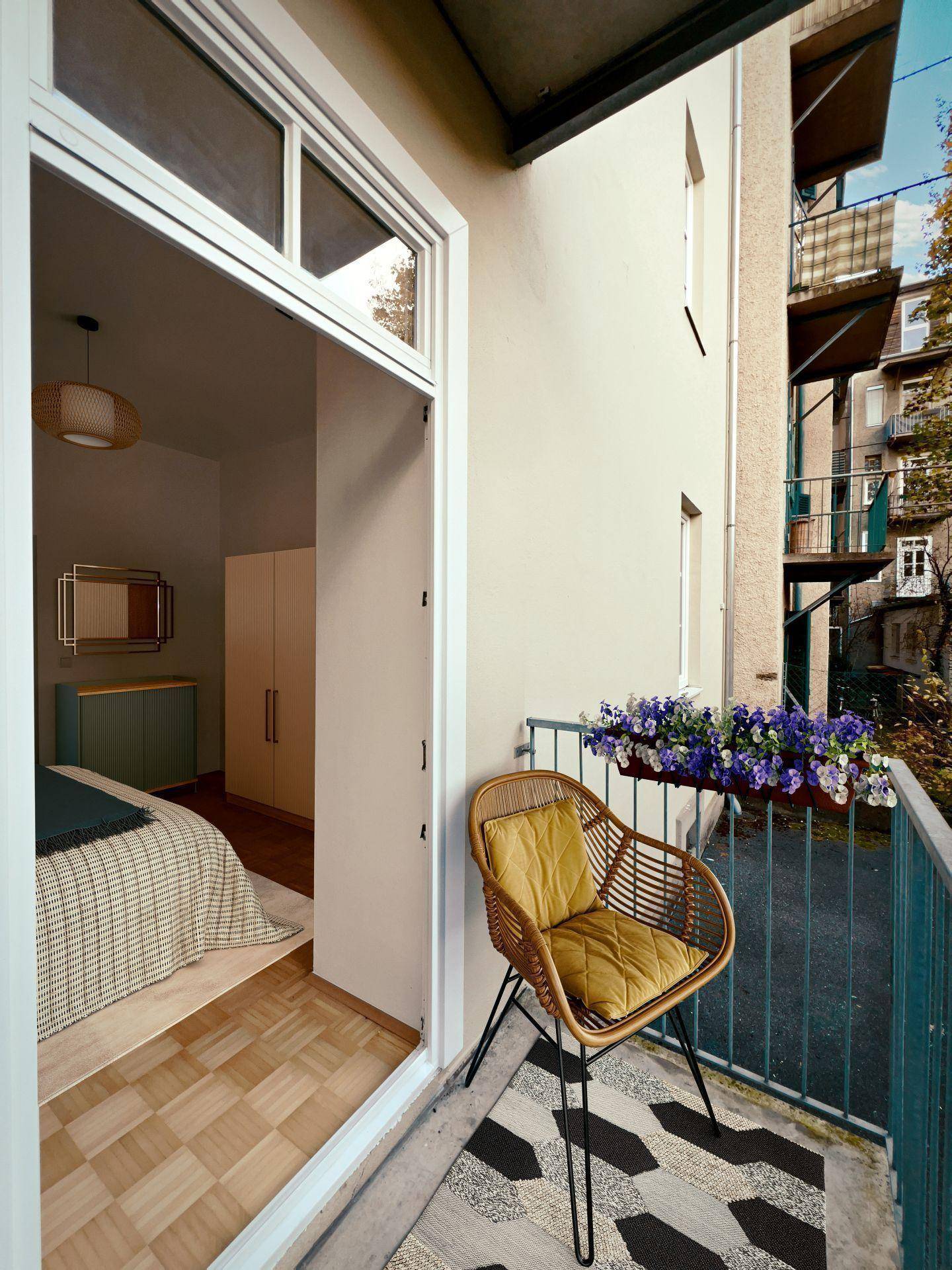 Kleiner Balkon mit Sitzgelegenheit und Blumenkästen, zugänglich vom Schlafzimmer.
