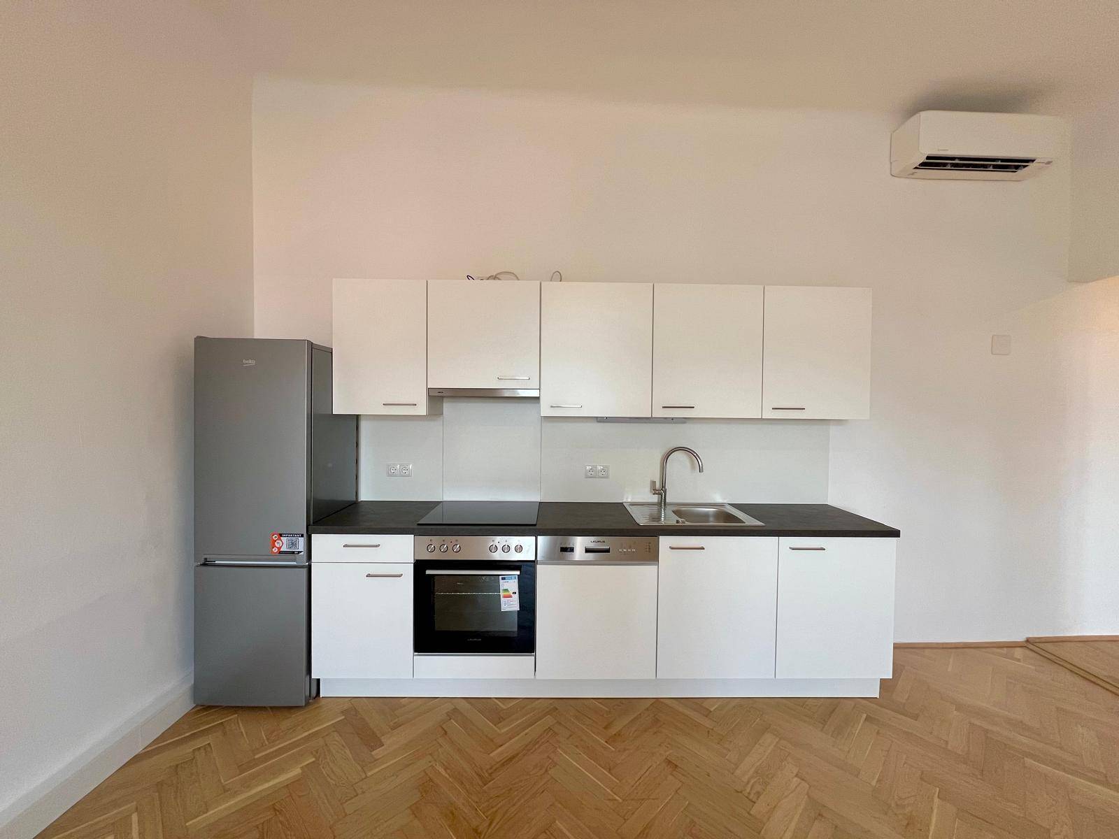 Moderne Einbauküche mit weißen Schränken, integrierten Geräten und Klimaanlage.
