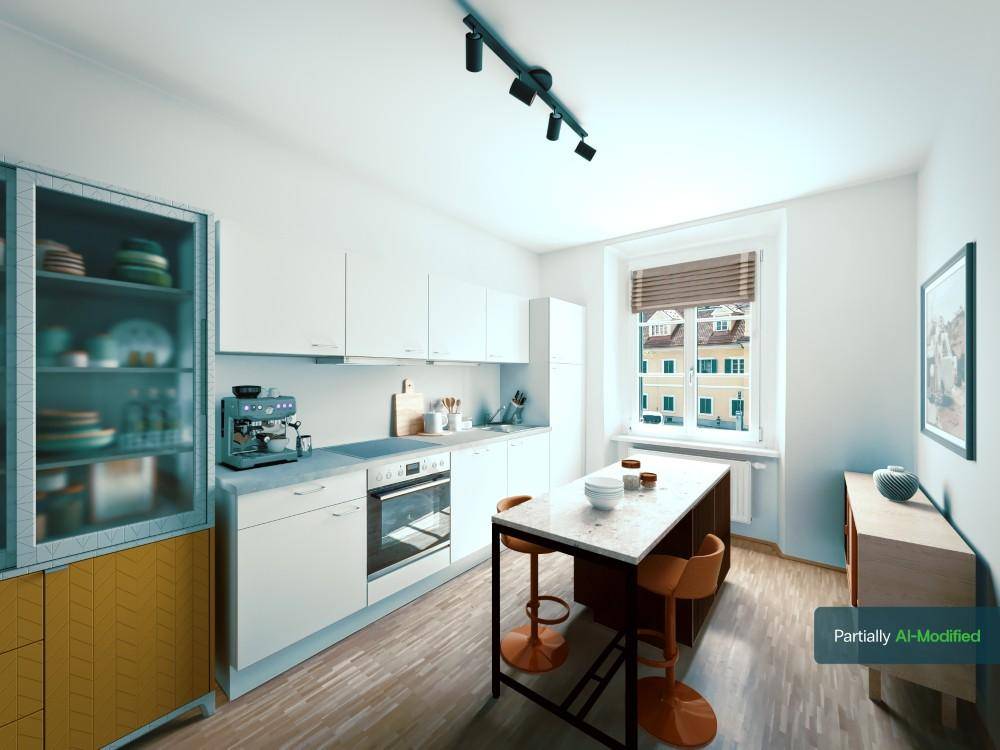 Moderne Küche mit weißen Schränken, Kücheninsel und Blick aus dem Fenster.