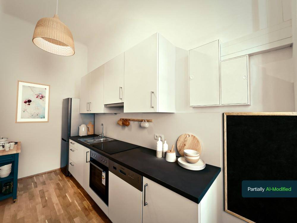Moderne Einbauküche mit weißen Schränken, dunkler Arbeitsplatte und integrierten Geräten.