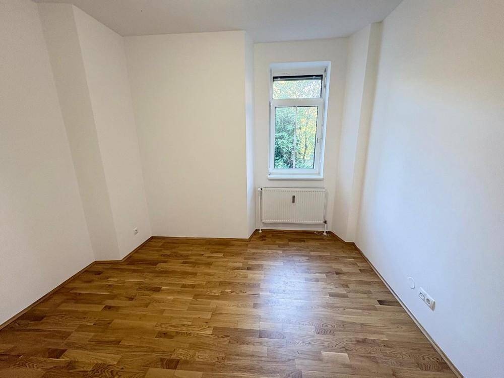 Gemütliches Zimmer mit Parkettboden und einem Fenster, geeignet als Schlaf- oder Arbeitszimmer.