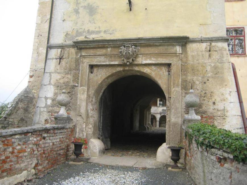 Historischer Torbogen als Eingang zum Anwesen mit alter Steinbrücke und Ziegelmauerwerk.