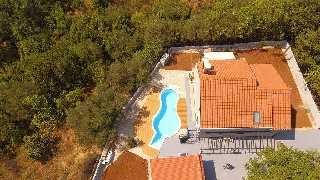 Draufsicht auf das Anwesen mit Pool, Dachflächenfenstern und weitläufigem Grundstück.