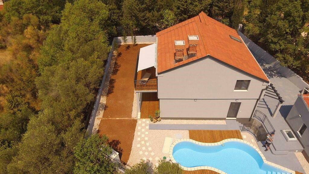 Luftaufnahme des Anwesens mit Pool, Terrasse und umgebender grüner Landschaft.