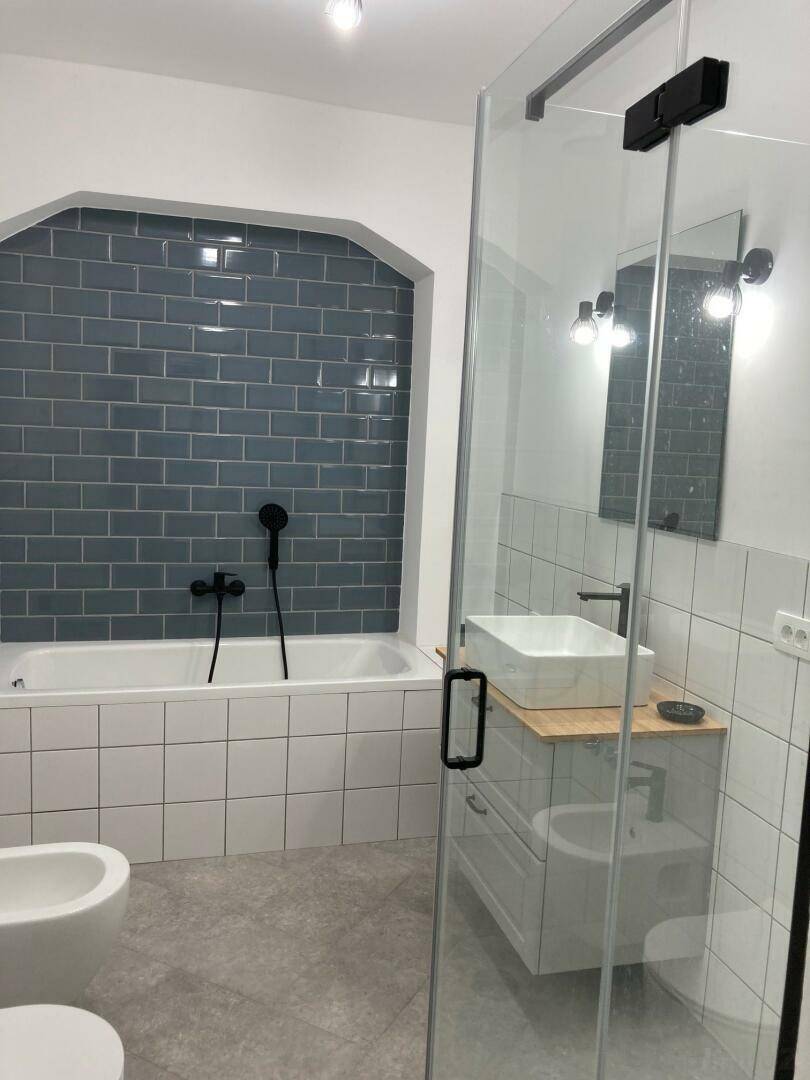 Modernes Badezimmer mit Badewanne, Duschkabine und stilvollen Fliesen.