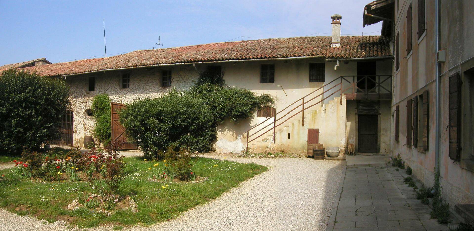 Innenhof mit einem kleinen Gartenbeet und den Fassaden der historischen Gebäude.