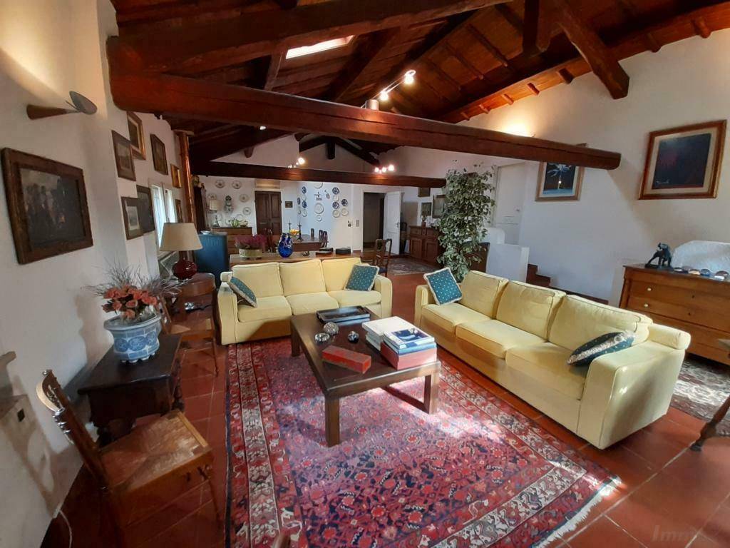 Rustikales Wohnzimmer mit freiliegenden Holzbalken, Terrakottaboden und traditionellen Möbeln.