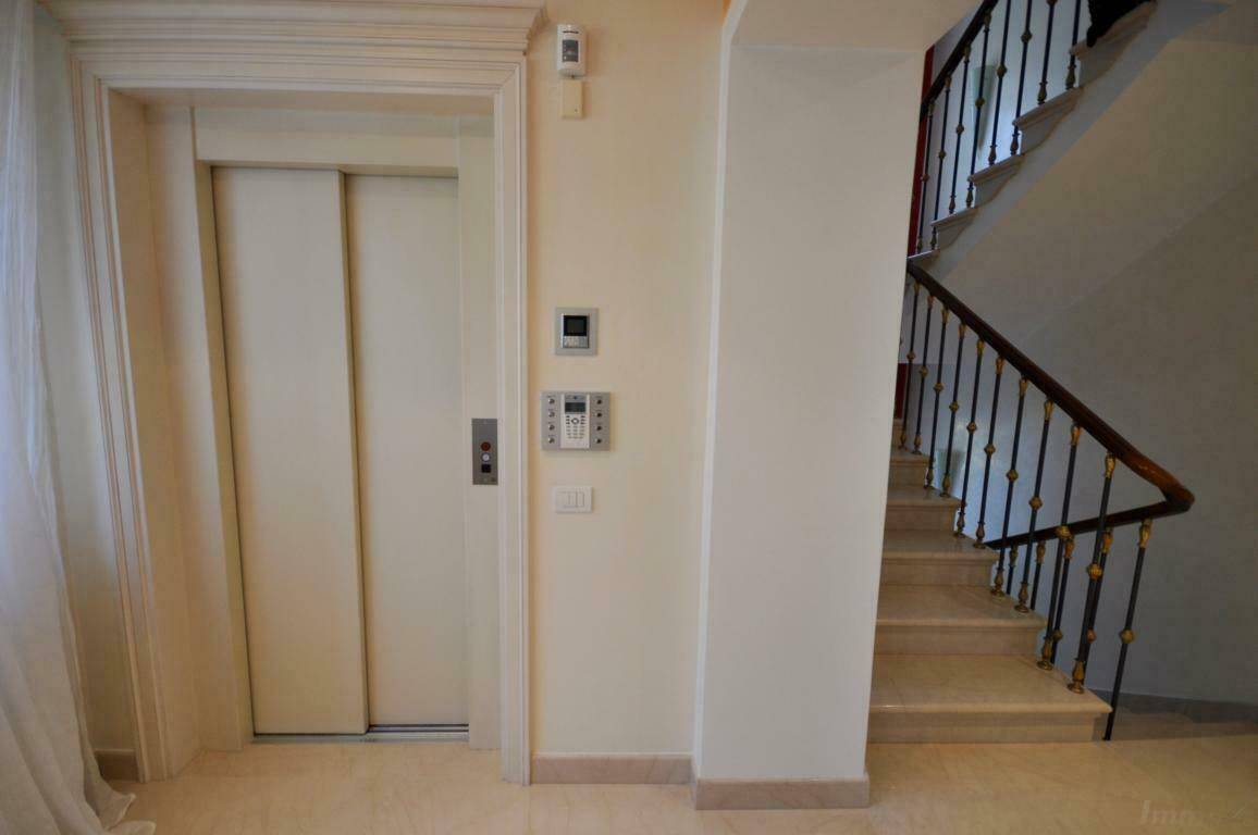 Eleganter Flur mit Aufzug und Marmortreppe, die zu den oberen Etagen des Hauses führt.