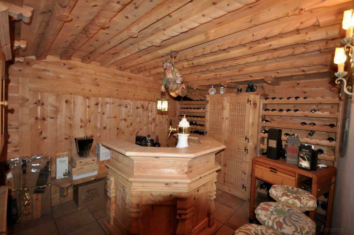 Rustikaler Weinkeller mit Holzvertäfelung, Bar und zahlreichen Weinregalen für Liebhaber.