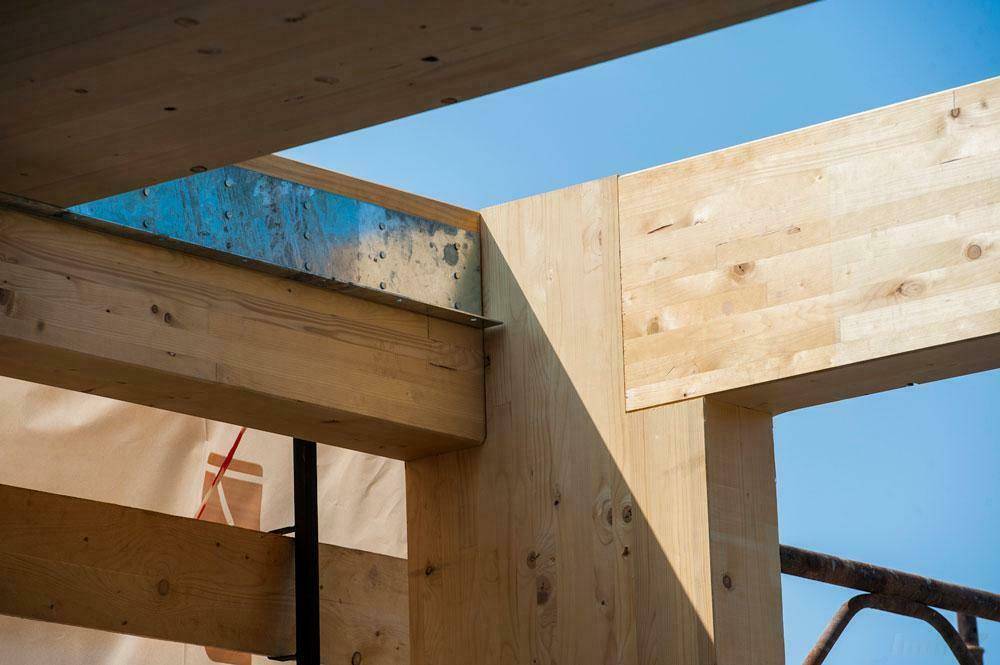 Holzkonstruktion eines im Bau befindlichen Gebäudes unter blauem Himmel.