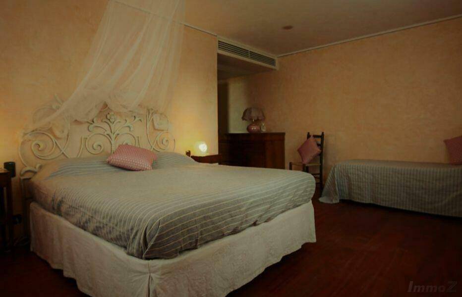 Gemütliches Schlafzimmer mit Himmelbett, Holzboden und traditioneller Einrichtung.