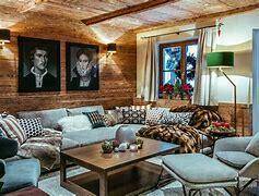 Rustikales Wohnzimmer mit Holzwänden, bequemen Sofas und traditionellen Kunstwerken an der Wand.