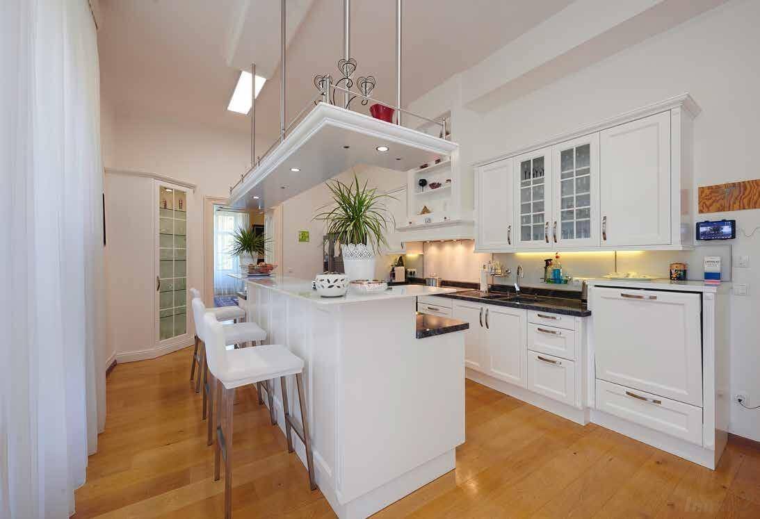 Helle, moderne Küche mit weißer Einbauküche, Kücheninsel und Holzboden.