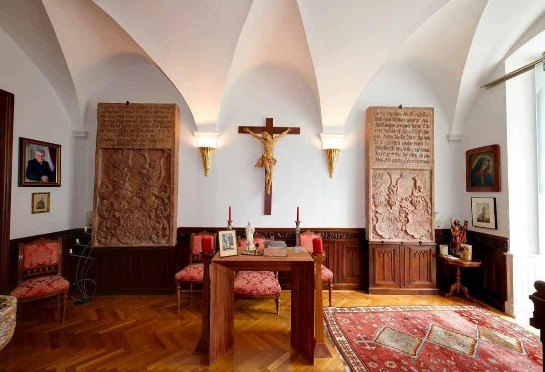 Historischer Raum mit Gewölbedecke, Holzboden und religiösen Kunstwerken.