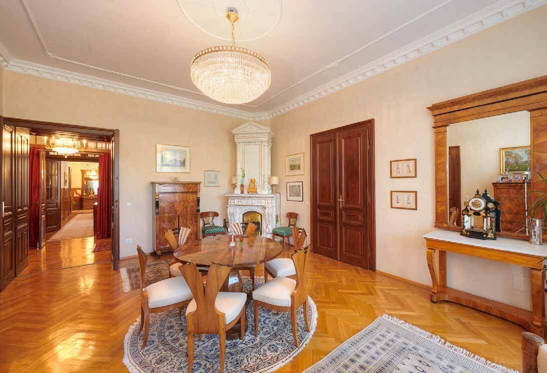 Elegantes Esszimmer mit Fischgrätparkett, Stuckdecke und einem prunkvollen Kamin.
