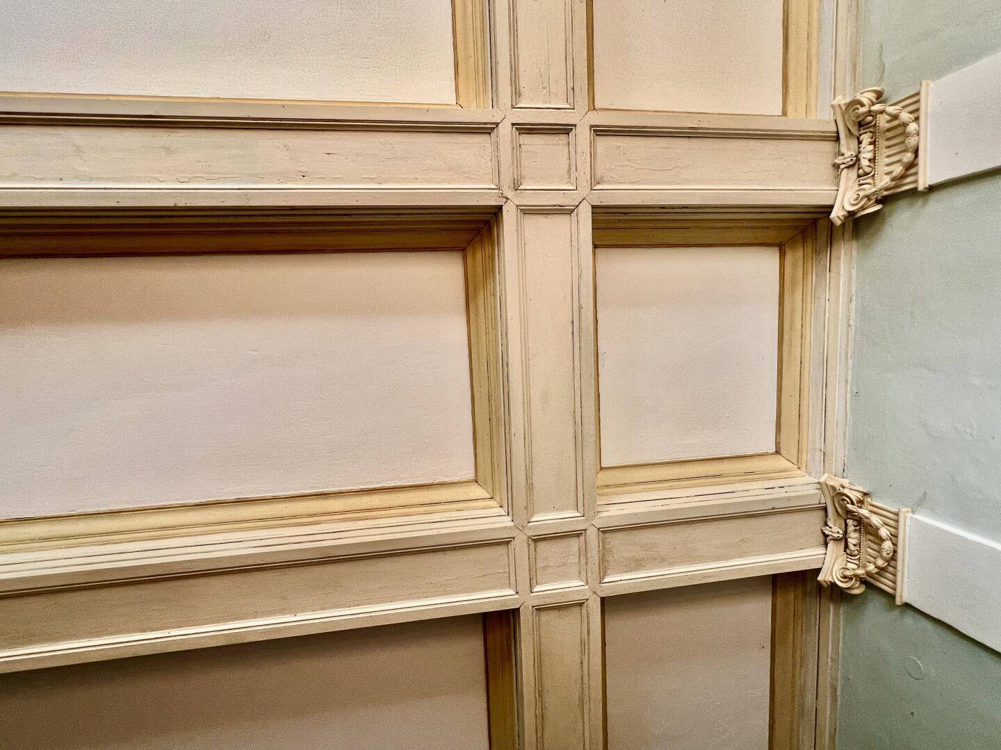 Detailansicht einer kunstvoll gestalteten Kassettendecke mit Stuckelementen.