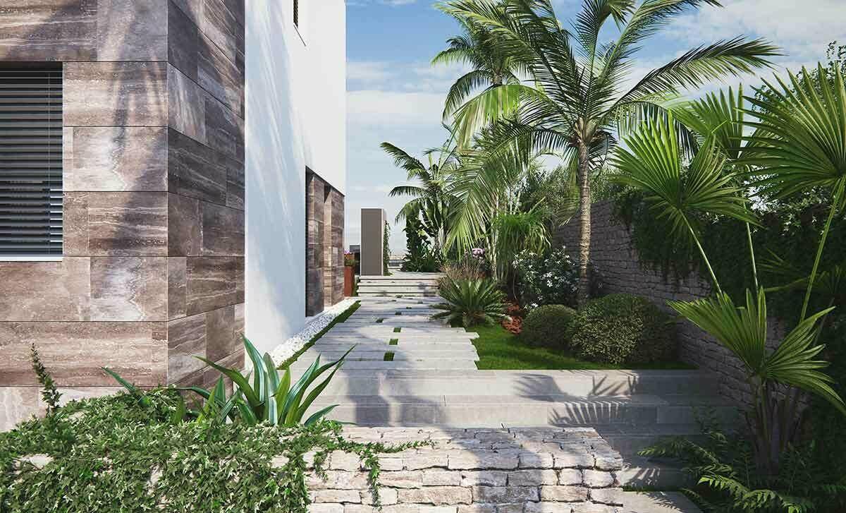 Gepflegter Gartenweg entlang der modernen Villa mit mediterraner Bepflanzung.