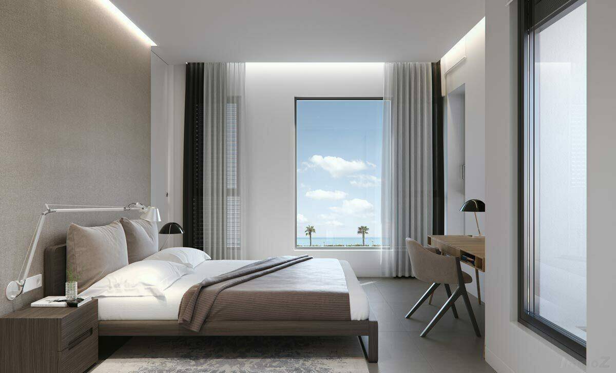 Modernes Schlafzimmer mit Meerblick, großem Fenster und integriertem Schreibtischbereich.