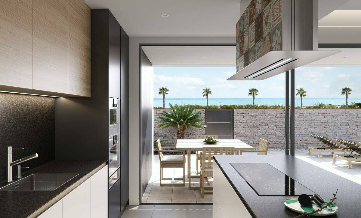 Moderne Küche mit Kochinsel, integrierten Geräten und direktem Zugang zur Terrasse mit Meerblick.