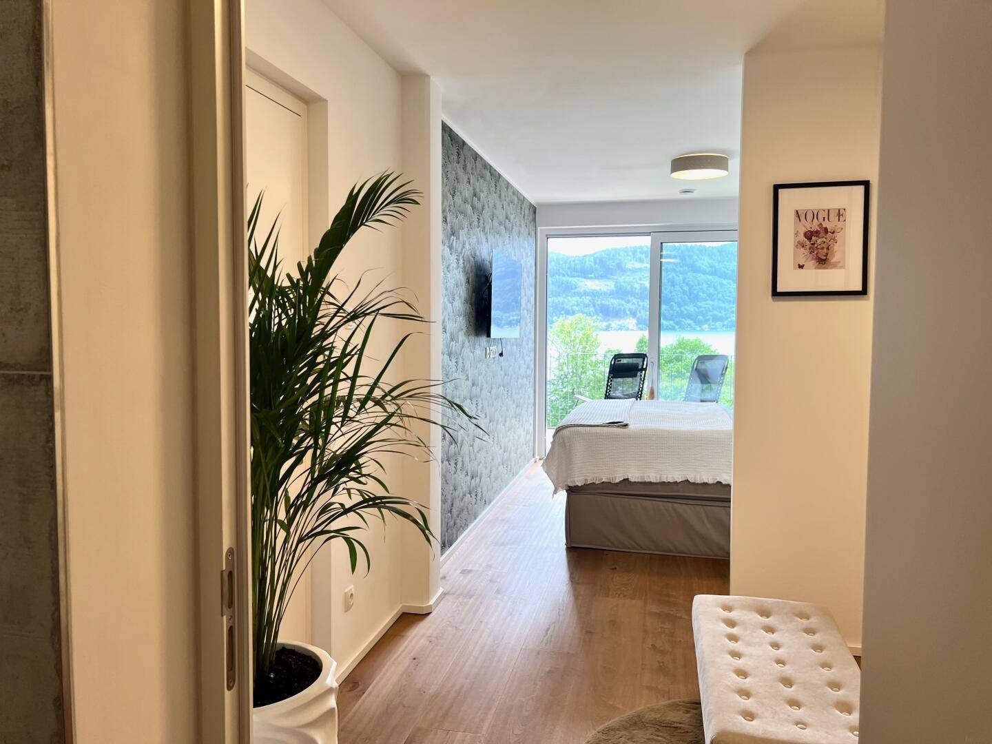 Blick vom Flur in ein Schlafzimmer mit Seeblick und modernem Design.