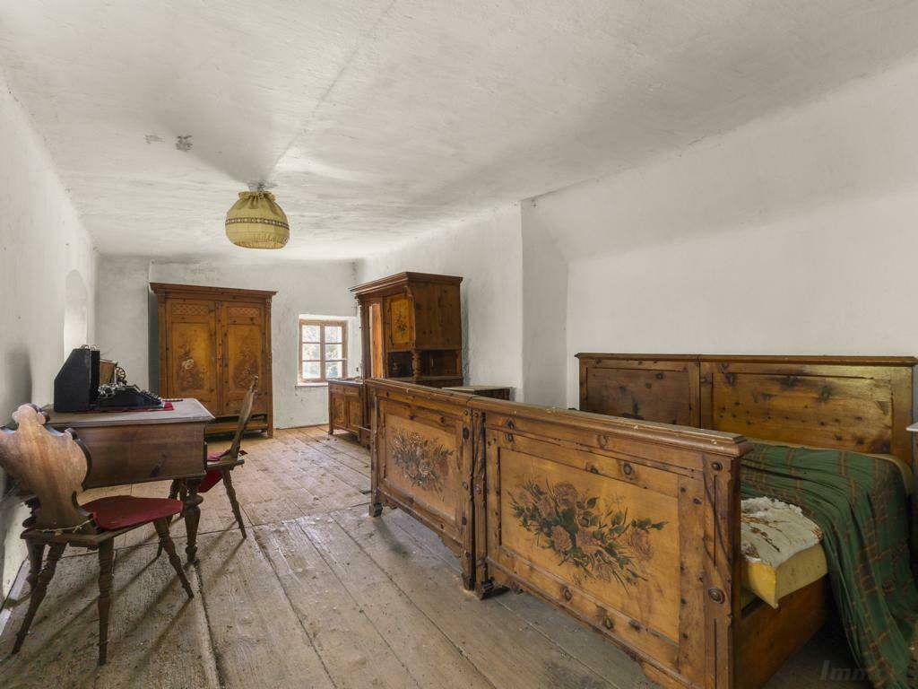 Rustikales Schlafzimmer mit Holzdielenboden und traditionellen, bemalten Holzmöbeln.