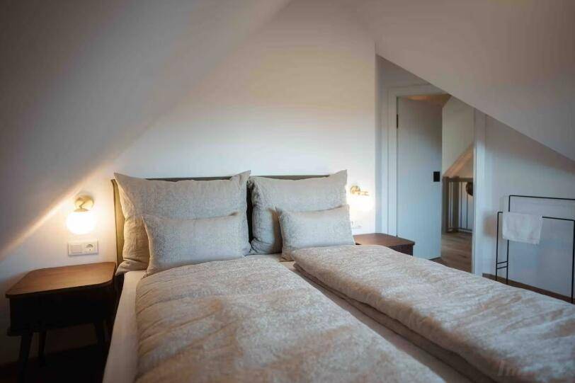 Gemütliches Schlafzimmer mit zwei Einzelbetten und schrägen Wänden im Dachgeschoss.