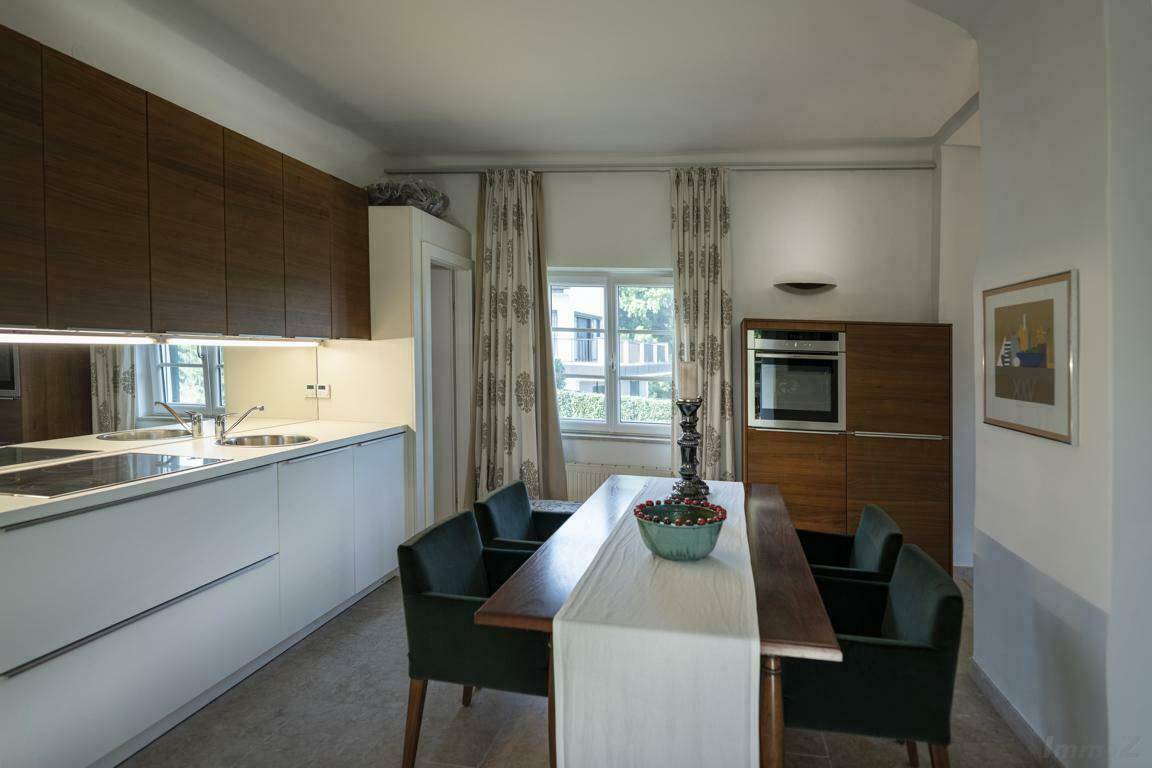 Funktionale Küche mit integrierten Geräten, Essbereich und Fenster mit Blick nach draußen.