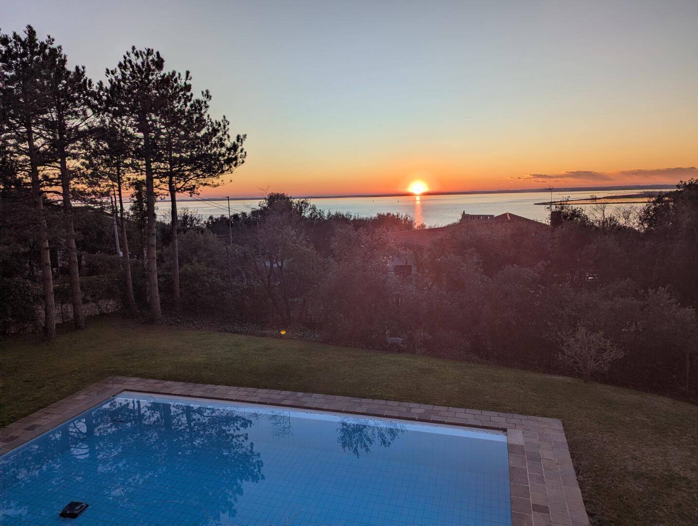 Atemberaubender Sonnenuntergang über dem Meer, gesehen vom Poolbereich des Anwesens.