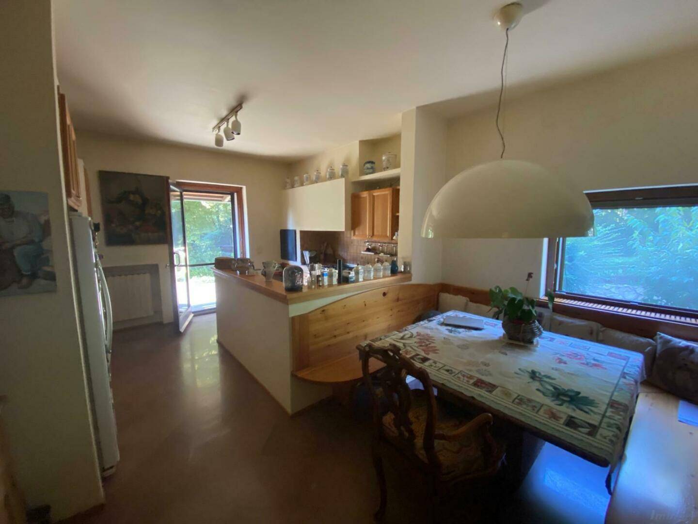 Gemütliche Wohnküche mit Holzelementen, Essbereich und Zugang zum Garten.