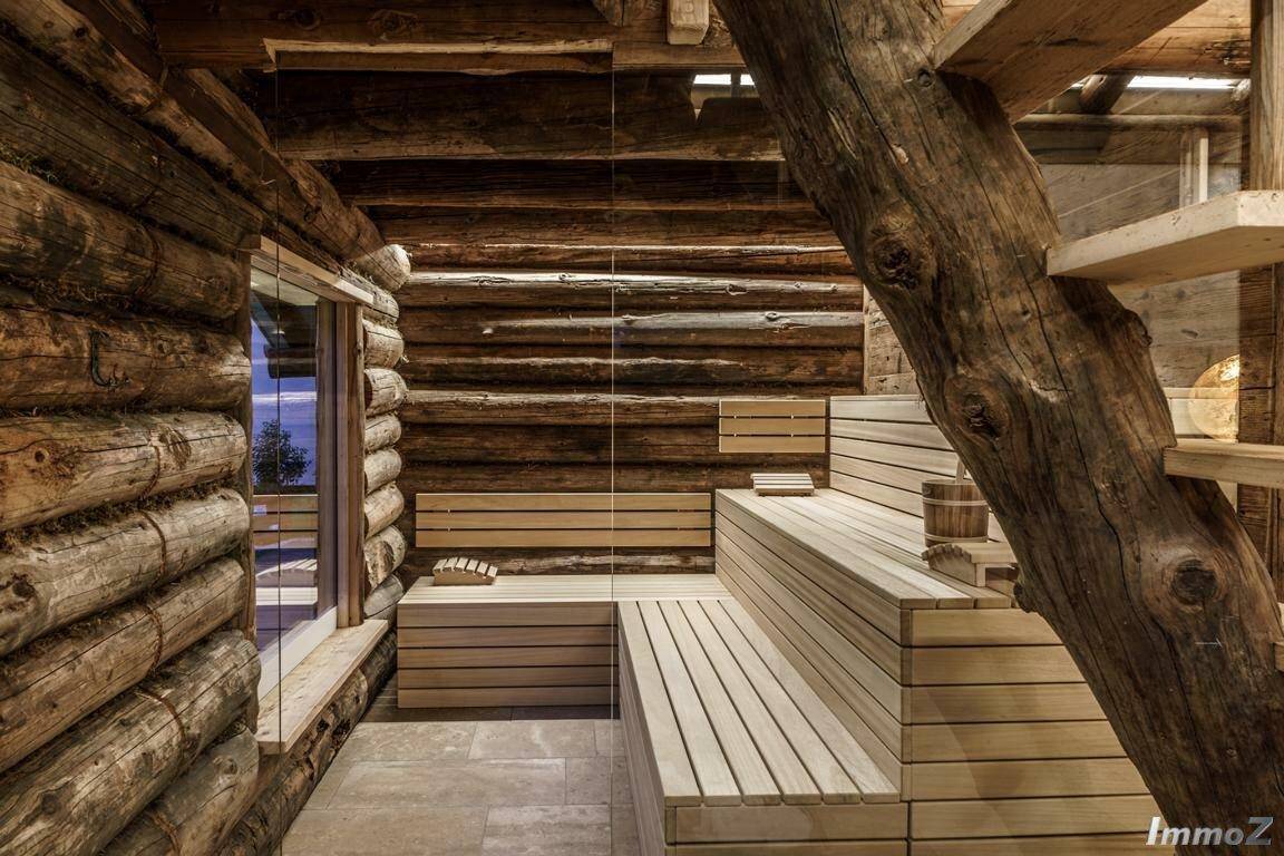 Geräumige Sauna mit Holzbänken und rustikalen Blockwänden für Entspannung.