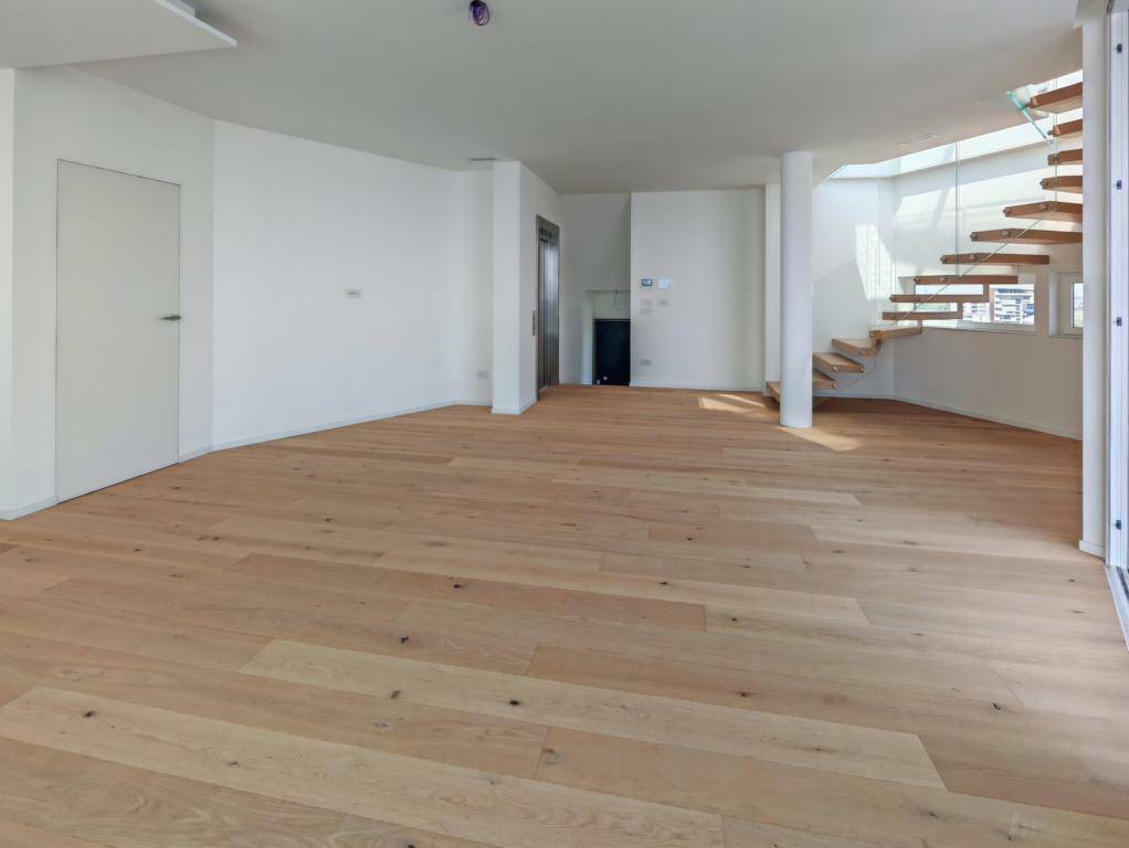 Geräumiger Wohnbereich mit Holzboden, eleganter Wendeltreppe und integriertem Aufzug.