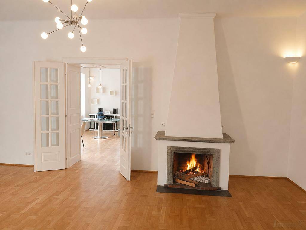 Geräumiges Wohnzimmer mit Kamin, Holzboden und Flügeltüren zu einem weiteren Raum.