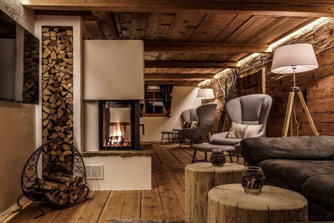 Gemütliches Wohnzimmer mit Kamin, Holzvertäfelung und bequemen Sesseln für entspannte Abende.