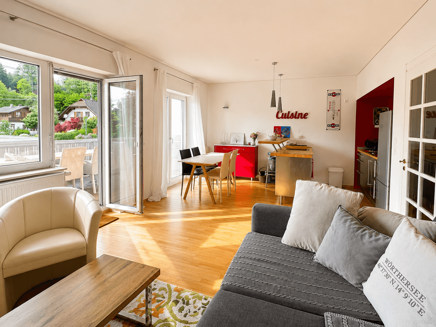 Heller Wohn-Essbereich mit Zugang zum Balkon und Blick ins Grüne.