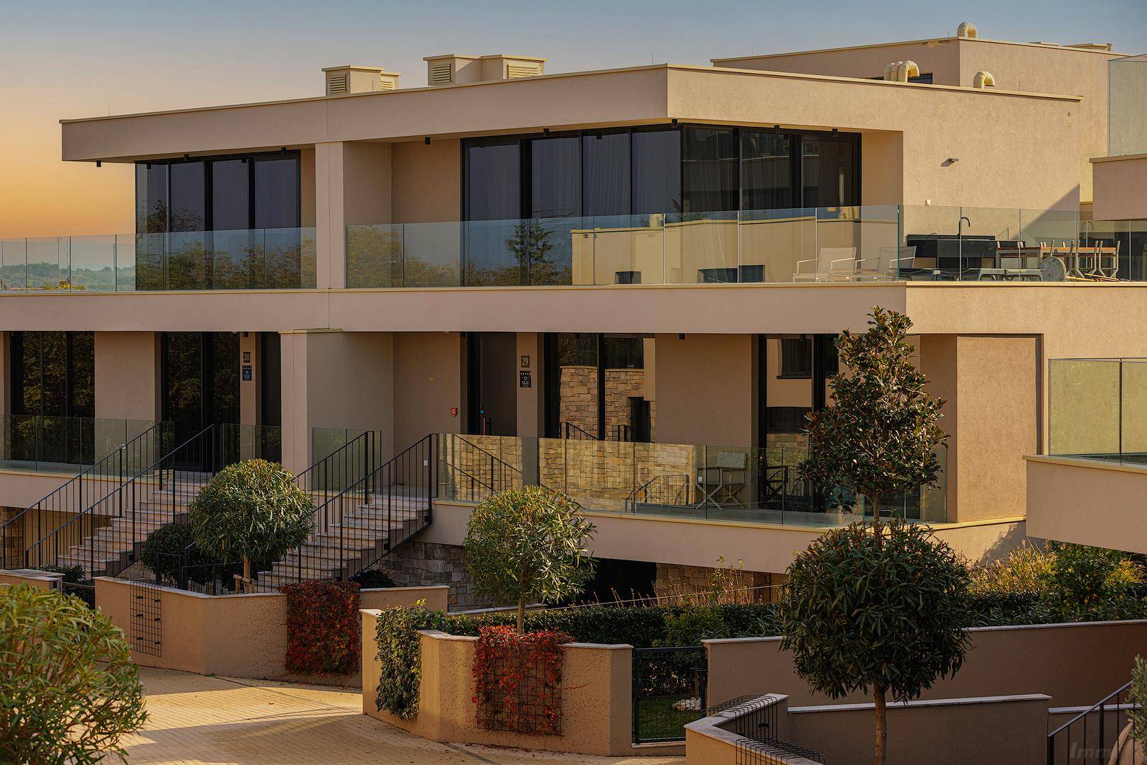 Moderne Architektur mit großen Glasfronten und Balkonen, die einen weiten Blick in die Landschaft bieten.