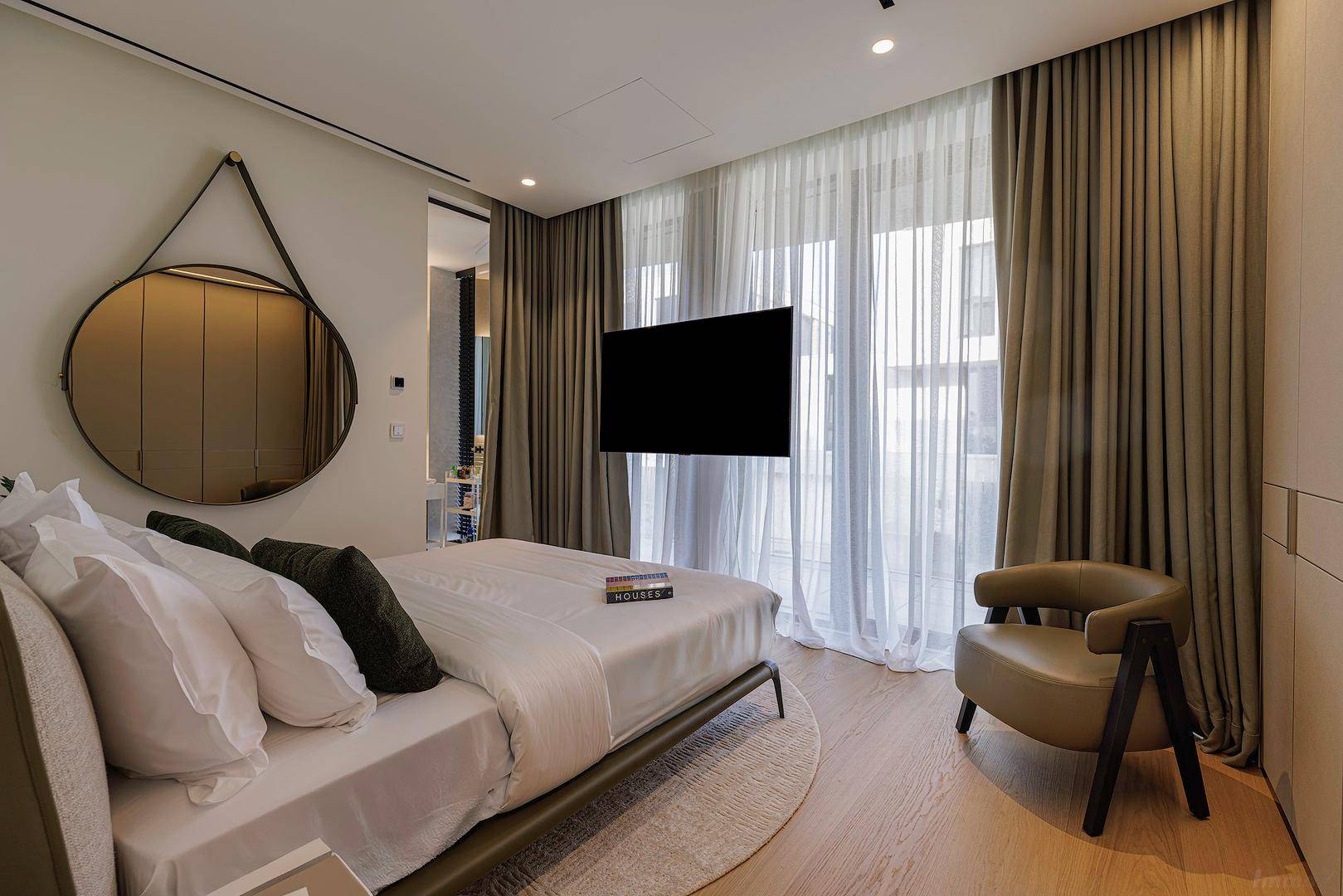 Elegantes Schlafzimmer mit Holzboden, großen Fenstern und modernem Interieur.