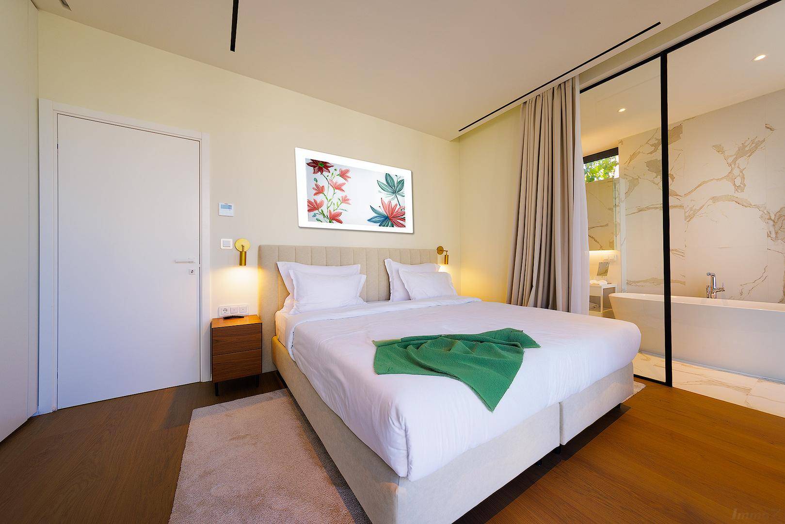 Modernes Schlafzimmer mit Holzboden und offenem Zugang zu einem luxuriösen Badezimmer.