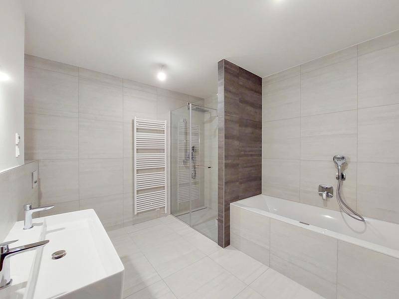Modernes Badezimmer mit Badewanne, Dusche, Doppelwaschbecken und beheiztem Handtuchhalter.