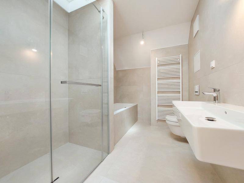 Modernes Badezimmer mit begehbarer Dusche, Badewanne und beheiztem Handtuchhalter.