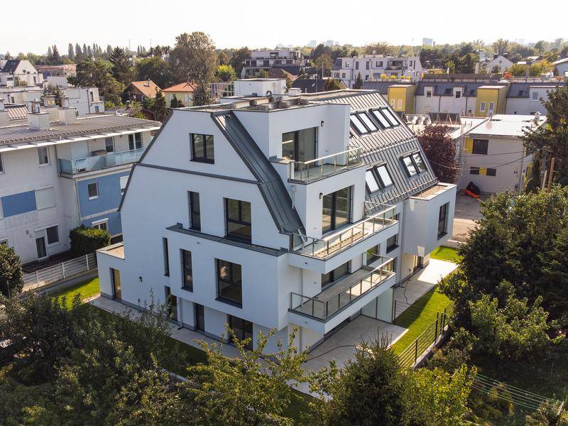 Neubau-Wohngebäude mit moderner Architektur, mehreren Balkonen und großen Fenstern.