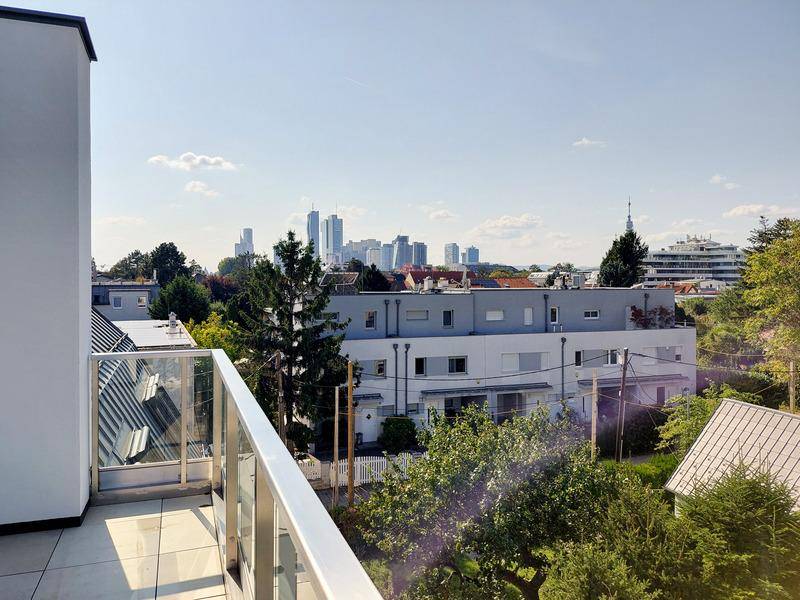 Sonniger Balkon mit weitem Blick über die Dächer und die Skyline der Stadt.