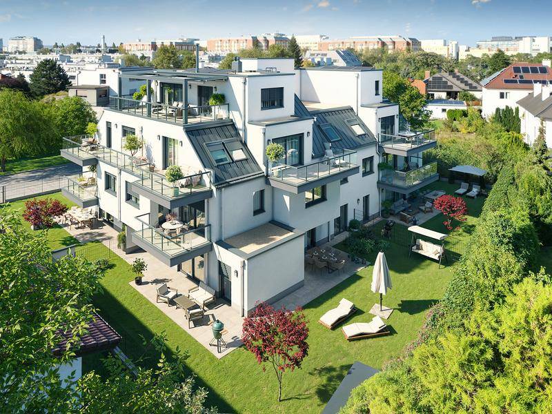 Luftaufnahme eines modernen Wohngebäudes mit mehreren Balkonen, Terrassen und einer gepflegten Gartenanlage.