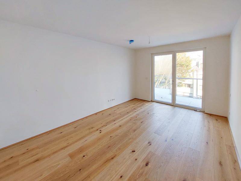 Lichtdurchflutetes Schlafzimmer mit elegantem Holzboden und großem Fenster.