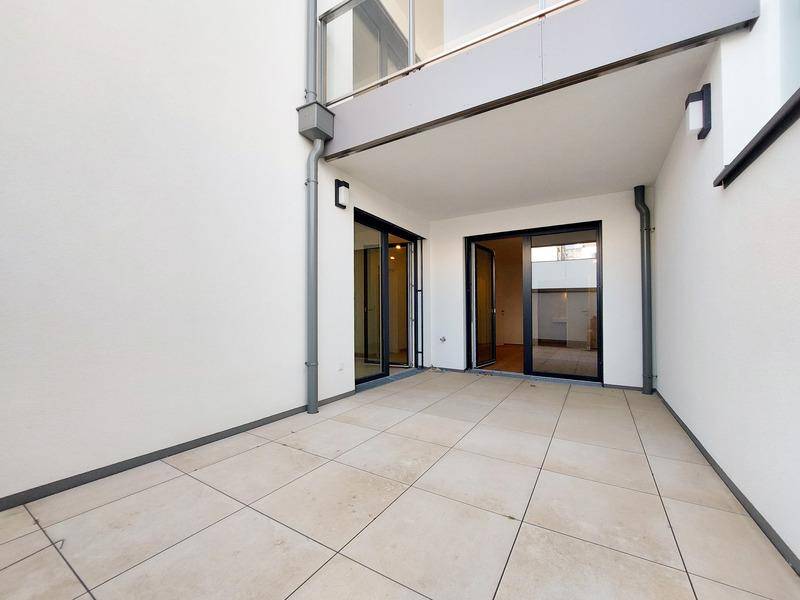 Große, geflieste Terrasse im Erdgeschoss mit direktem Zugang zu den Innenräumen des Gebäudes.