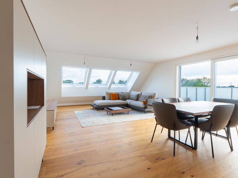 Geräumiger Wohn-Essbereich mit Dachfenstern, Holzboden und moderner Einrichtung.