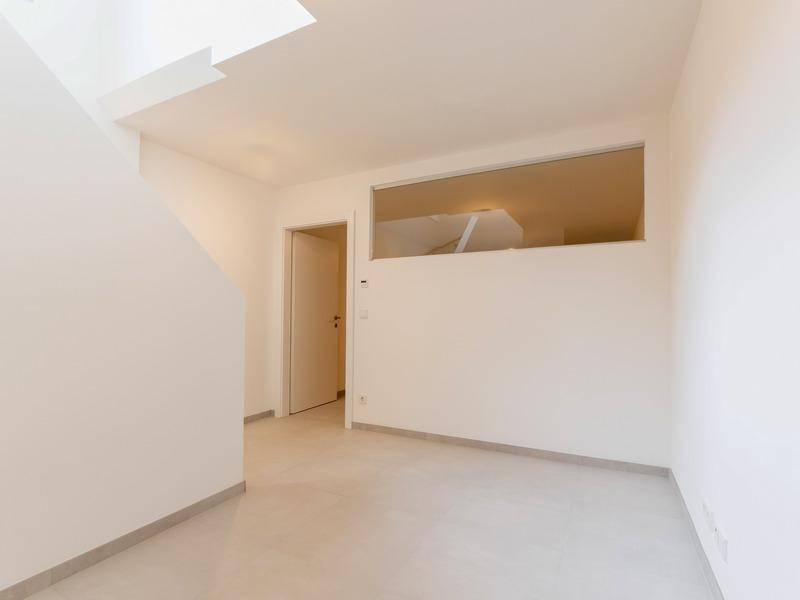 Heller Kellerraum mit Fliesenboden und einem hohen, horizontalen Fenster.