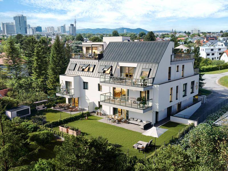 Luftaufnahme eines modernen Wohngebäudes mit Garten und Blick auf die Stadtkulisse.
