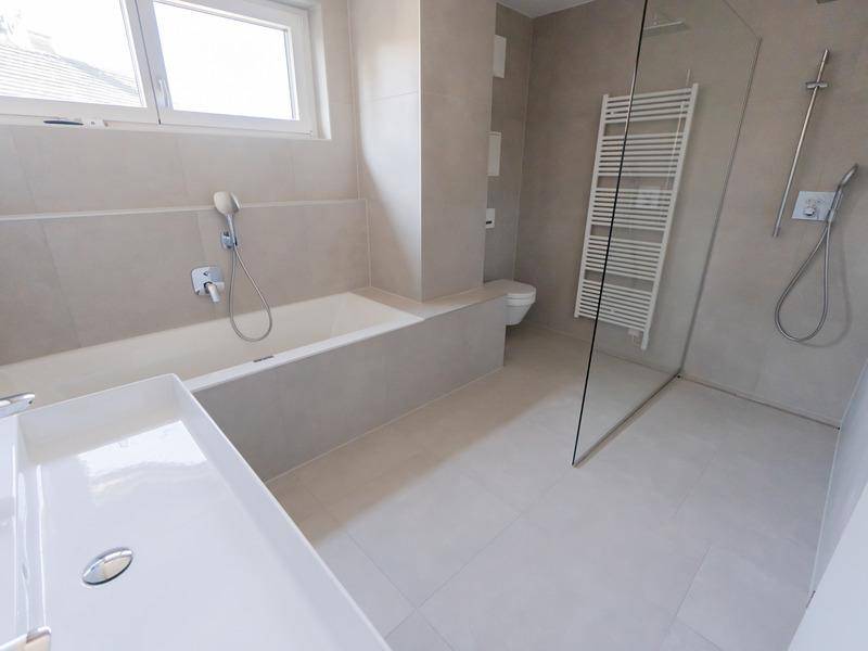 Modernes Badezimmer mit Badewanne, ebenerdiger Dusche, Einzelwaschbecken und Fenster.