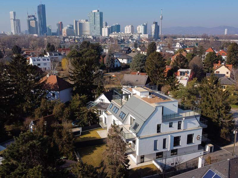 Moderne Wohnanlage mit Blick auf die Stadtkulisse und umliegende grüne Wohngebiete.